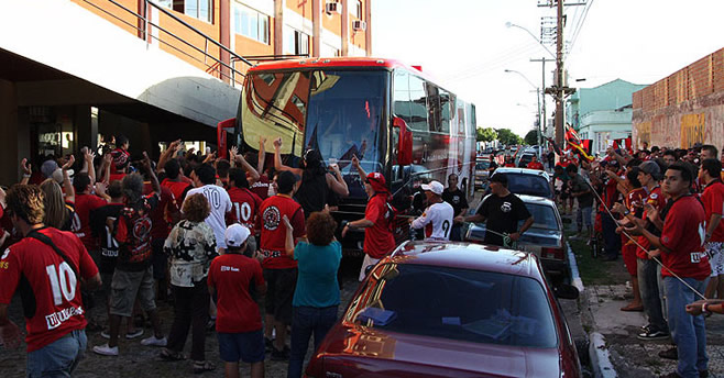 Chegada do novo ônibus ao Bento Freitas, com torcedores ao redor celebrando.