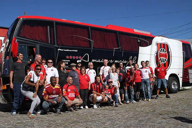 Torcedores sorteados para o city tour posam na frente do ônibus para a foto